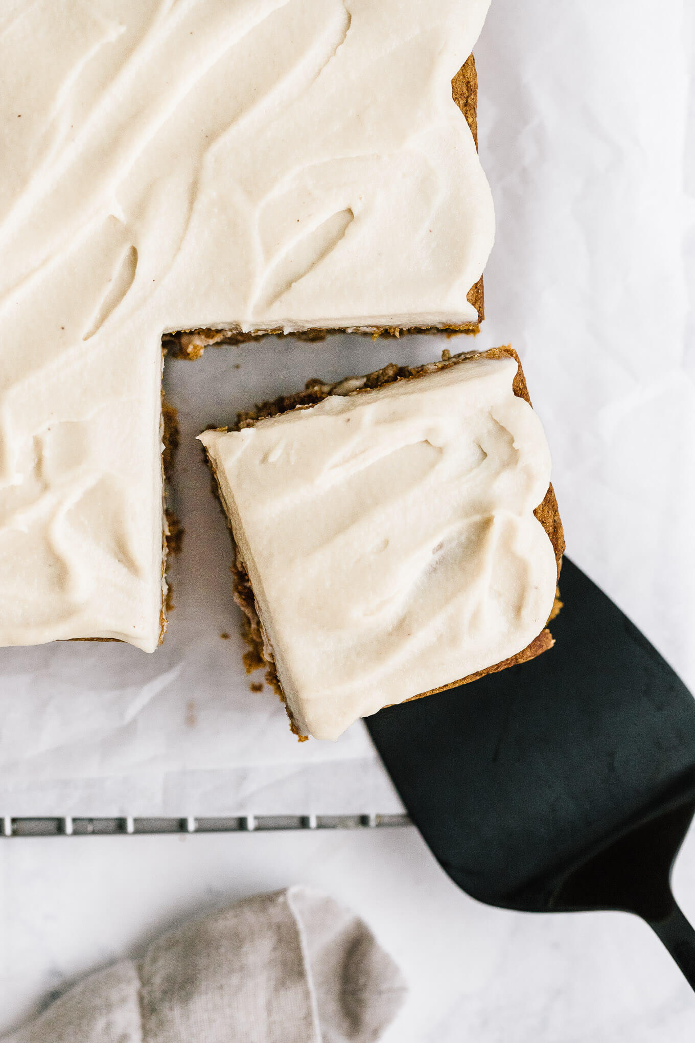 slice of pumpkin snack cake with cashew buttercream with spatula