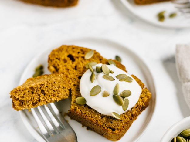 healthy pumpkin bread made with spelt flour and maple syrup on plate with dollop of yogurt