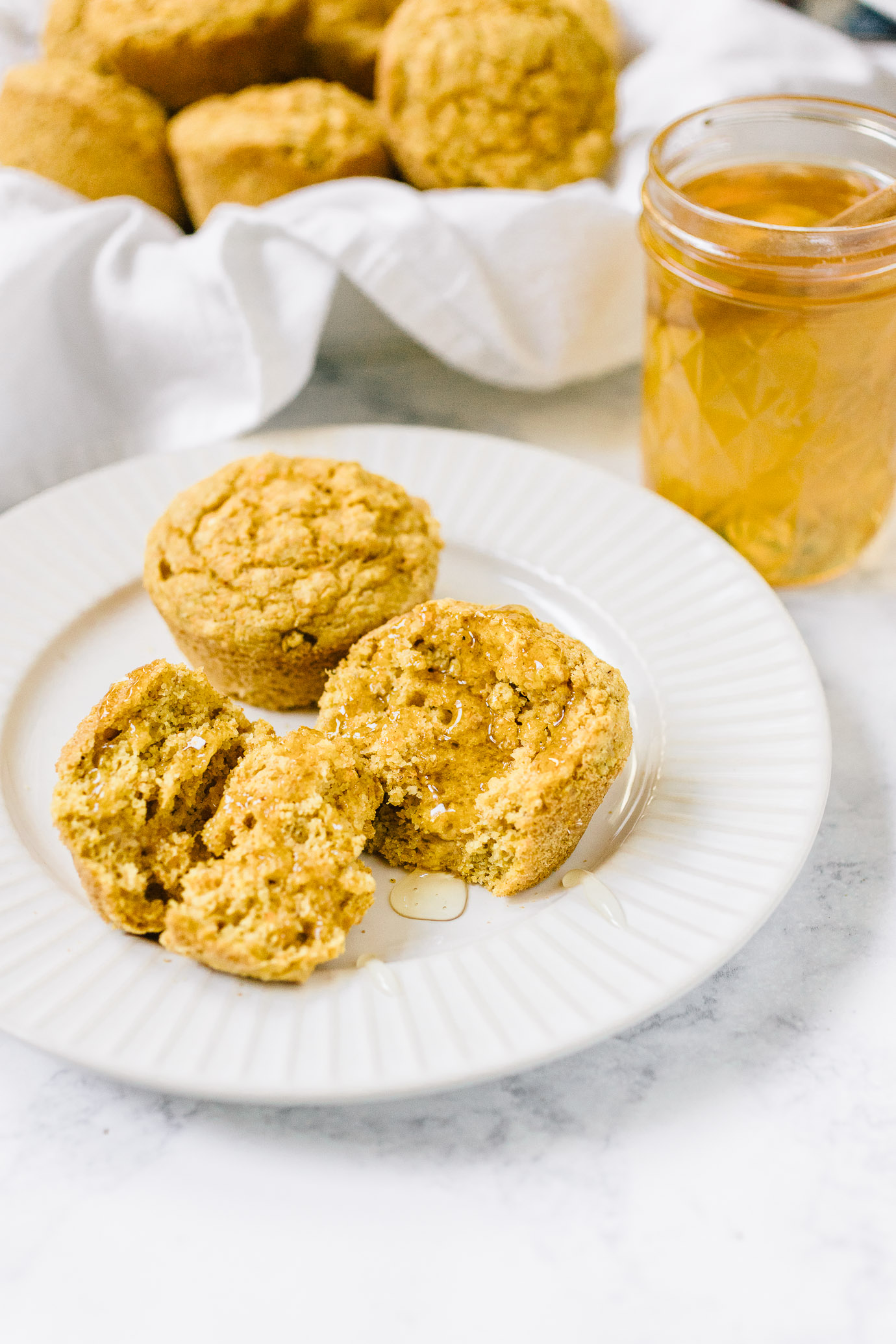 plate of maple cornbread muffins with honey