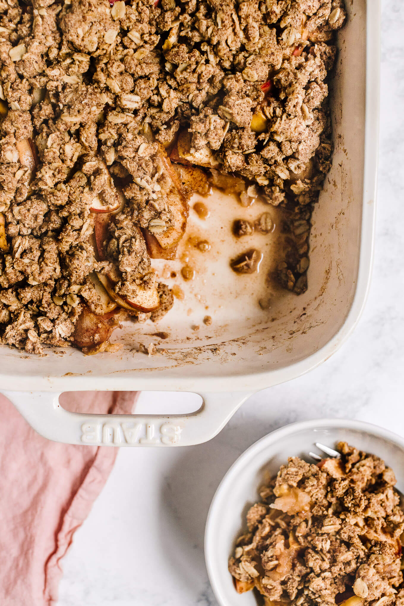 Almond butter apple crisp with portion missing and Small bowl of almond butter apple crisp
