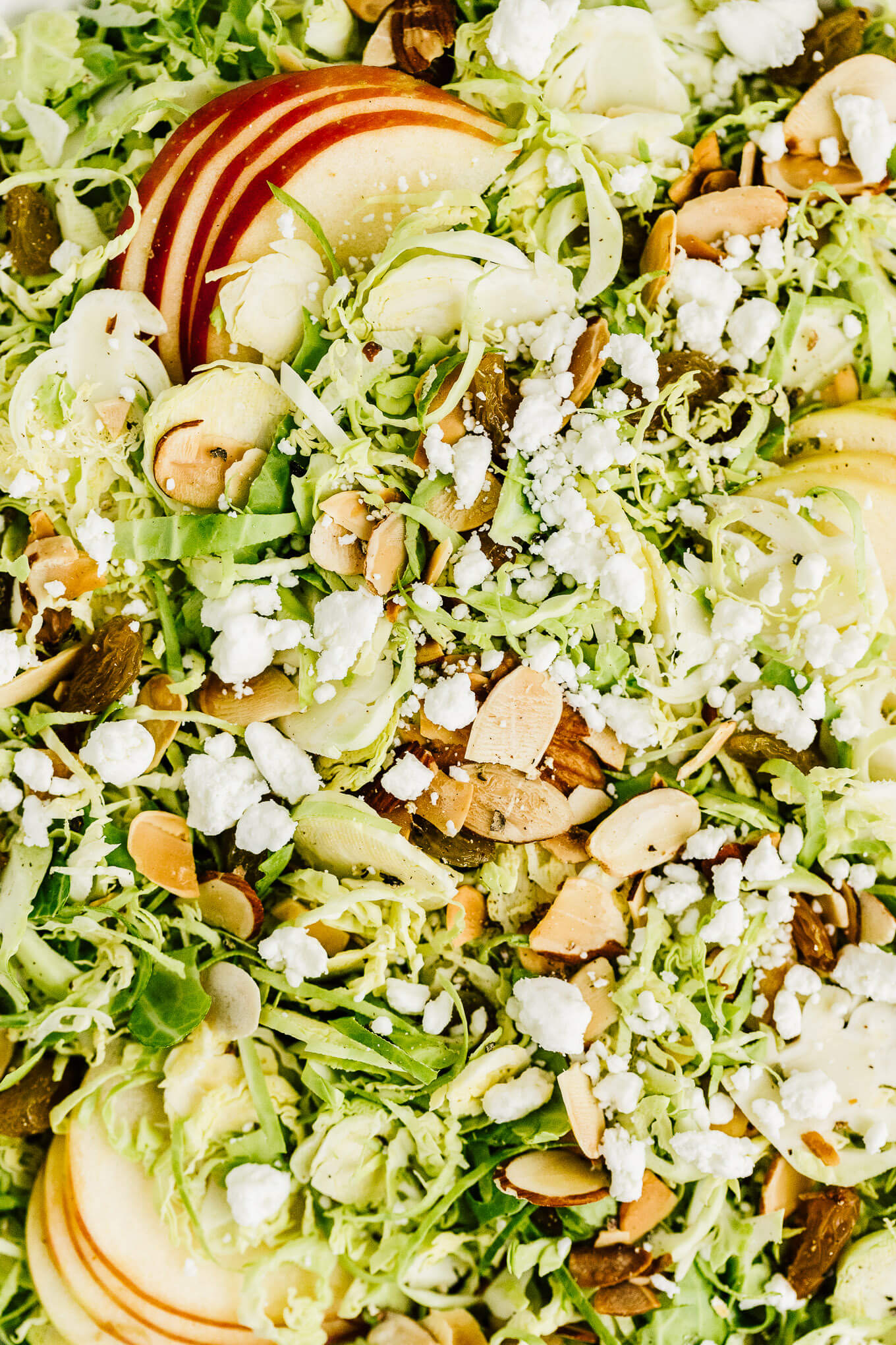 Shaved Brussels sprout and apples salad with golden raisins and goat cheese