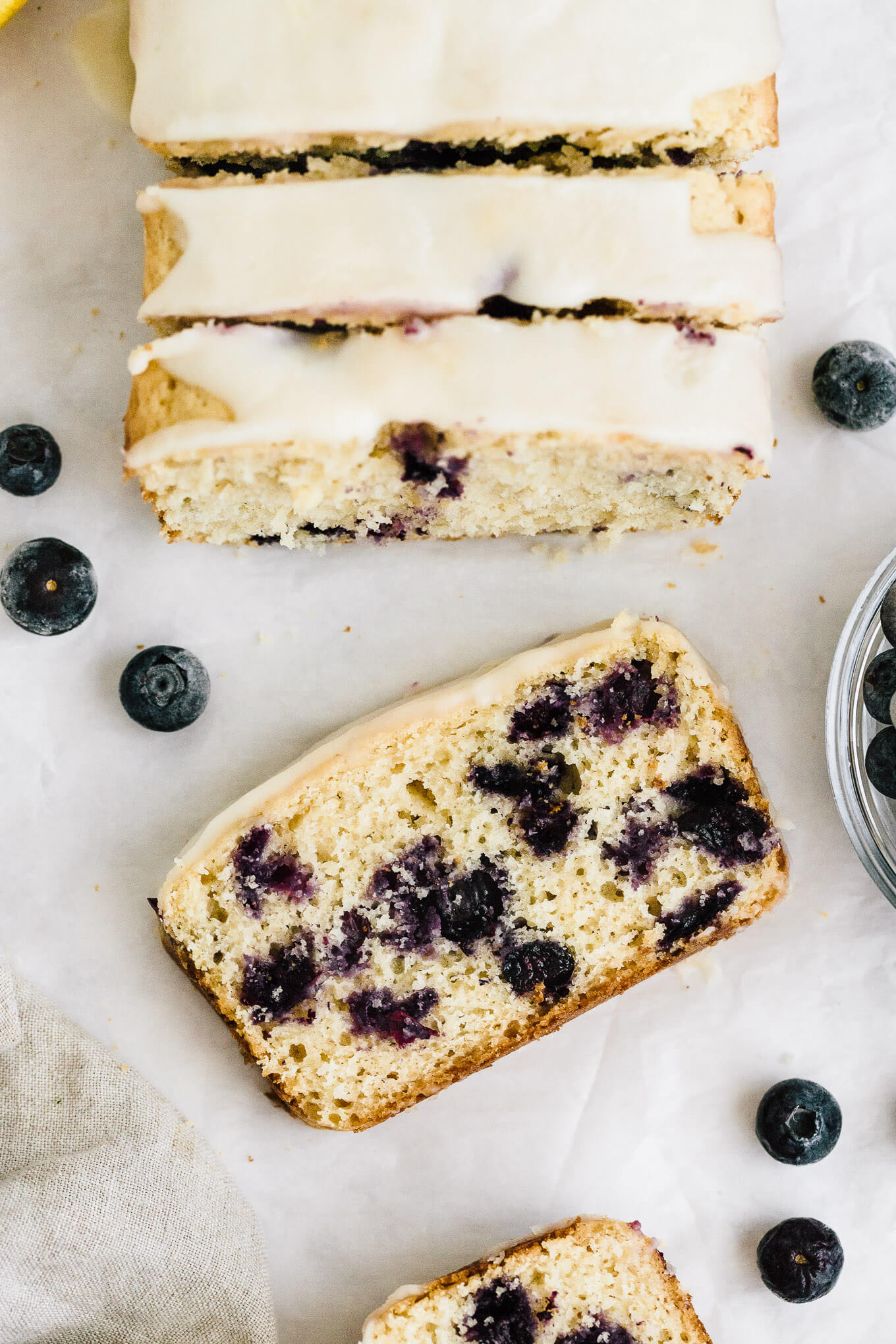Healthy lemon blueberry bread naturally sweetened with maple syrup and topped with a sweet lemon glaze slice