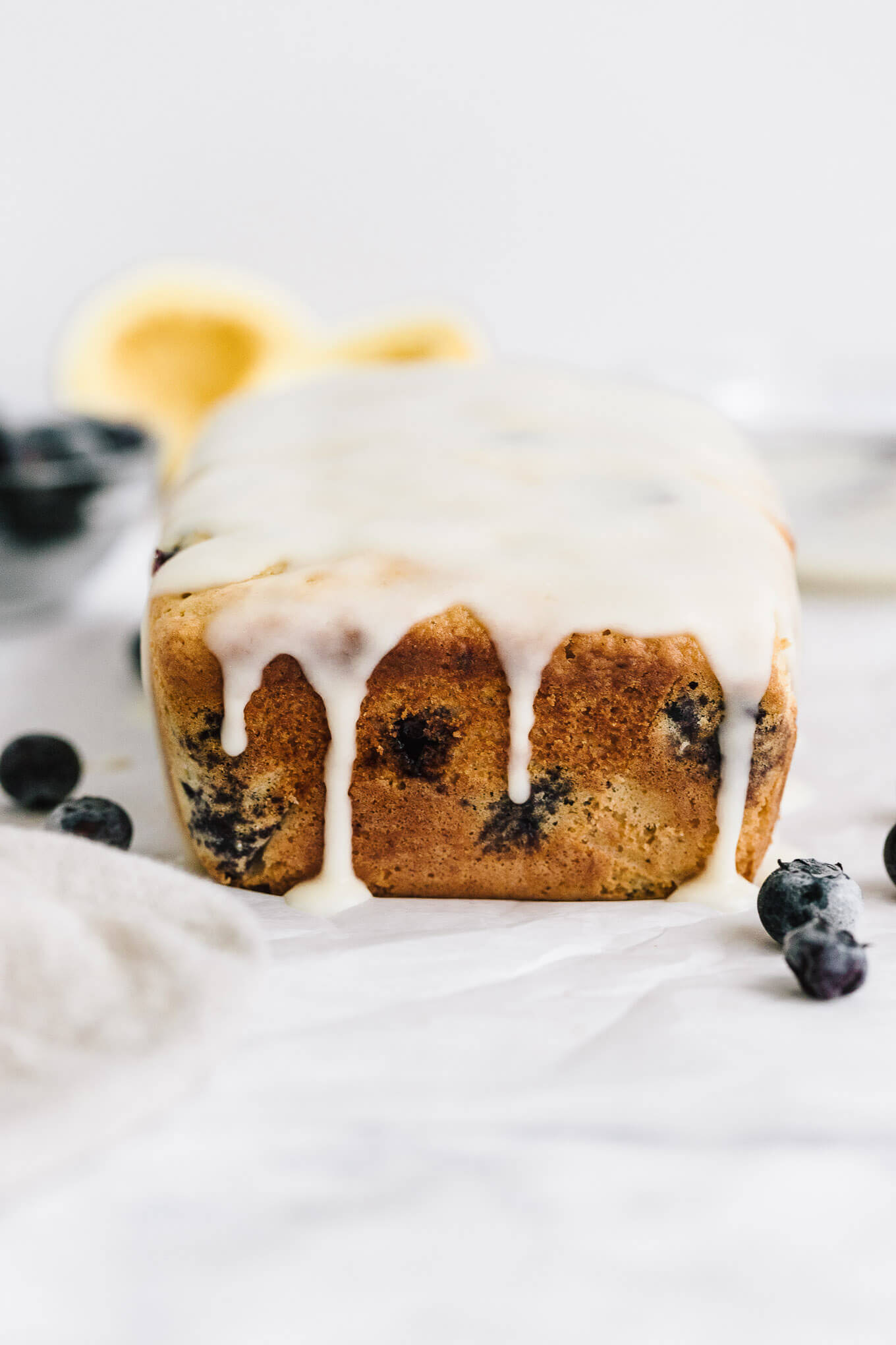 Healthy lemon blueberry bread naturally sweetened with maple syrup and topped with a sweet lemon glaze.
