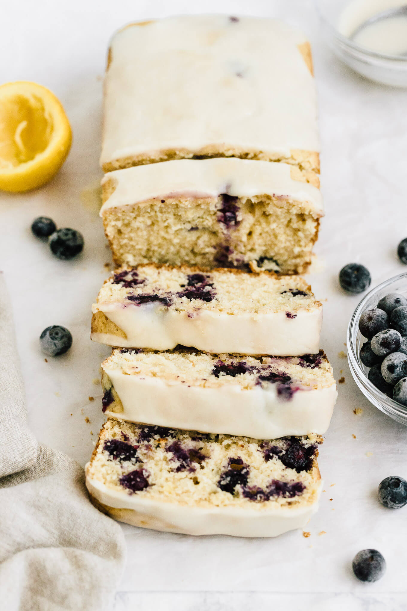 Healthy lemon blueberry bread naturally sweetened with maple syrup and topped with a sweet lemon glaze sliced