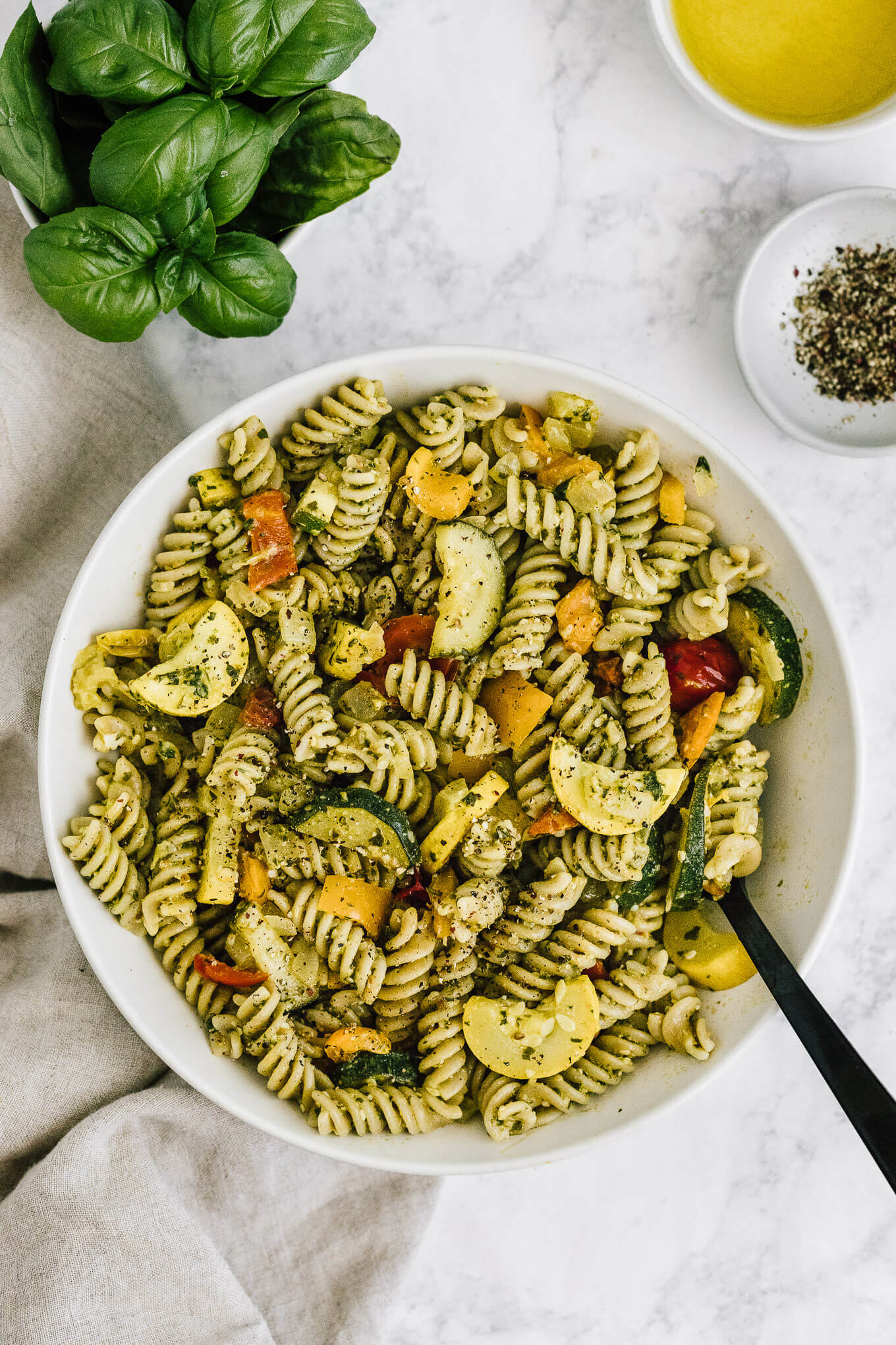 summer vegetable pesto pasta in serving bowl; gluten-free, dairy-free, vegan.