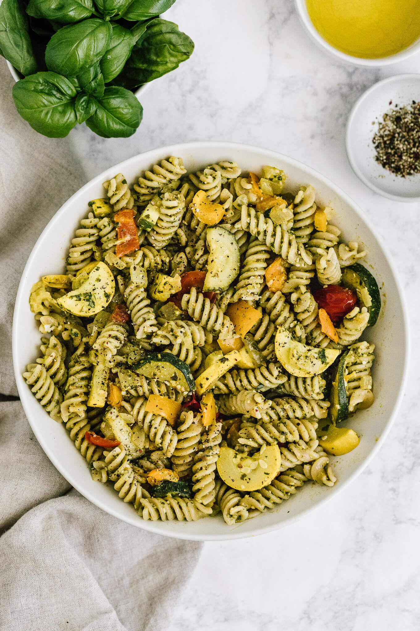 summer vegetable pesto pasta in serving bowl; gluten-free, dairy-free, vegan.