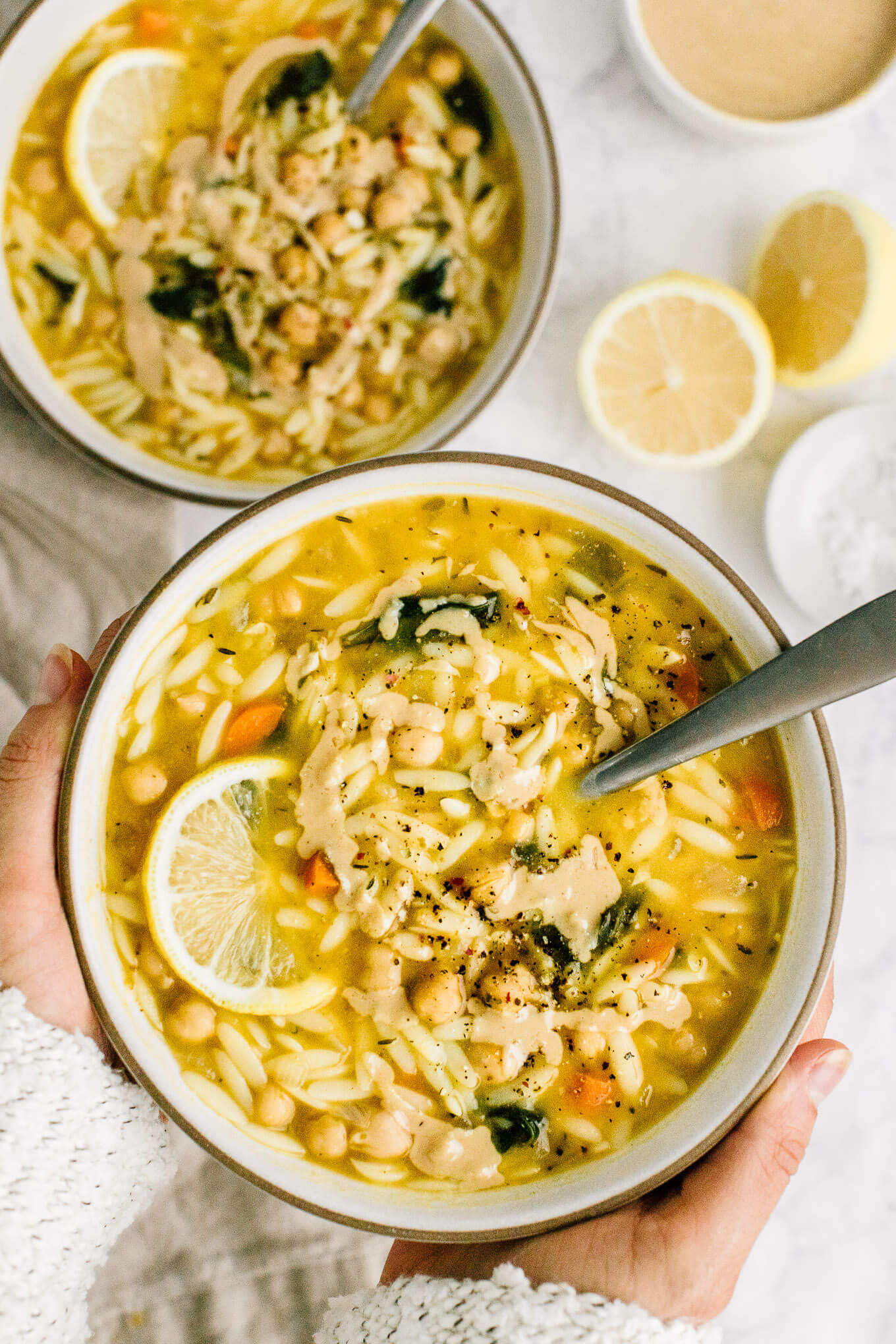 hands hold bowl lemon chickpea orzo sup