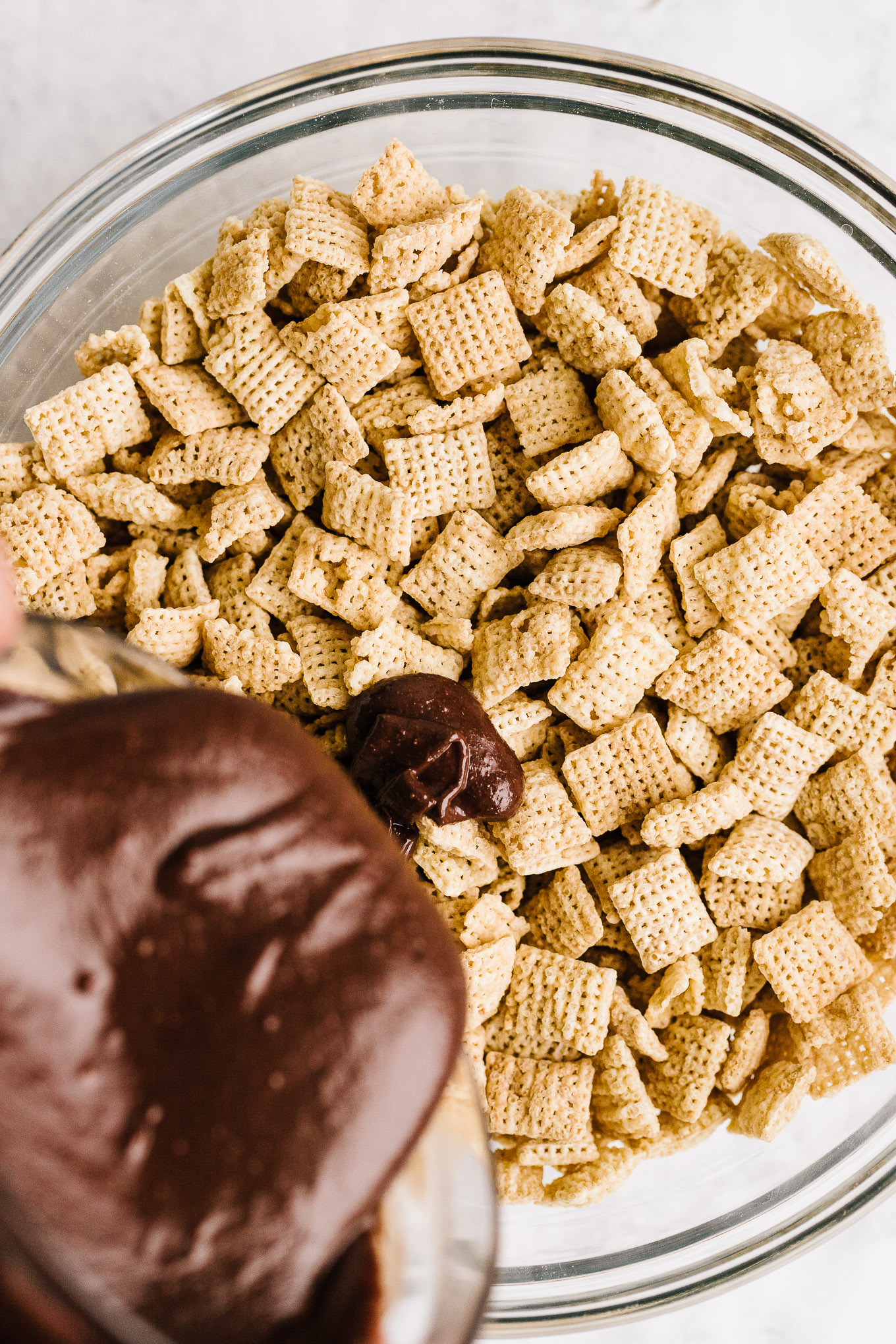 chocolate-peanut butter mixture pouring onto Chex cereal