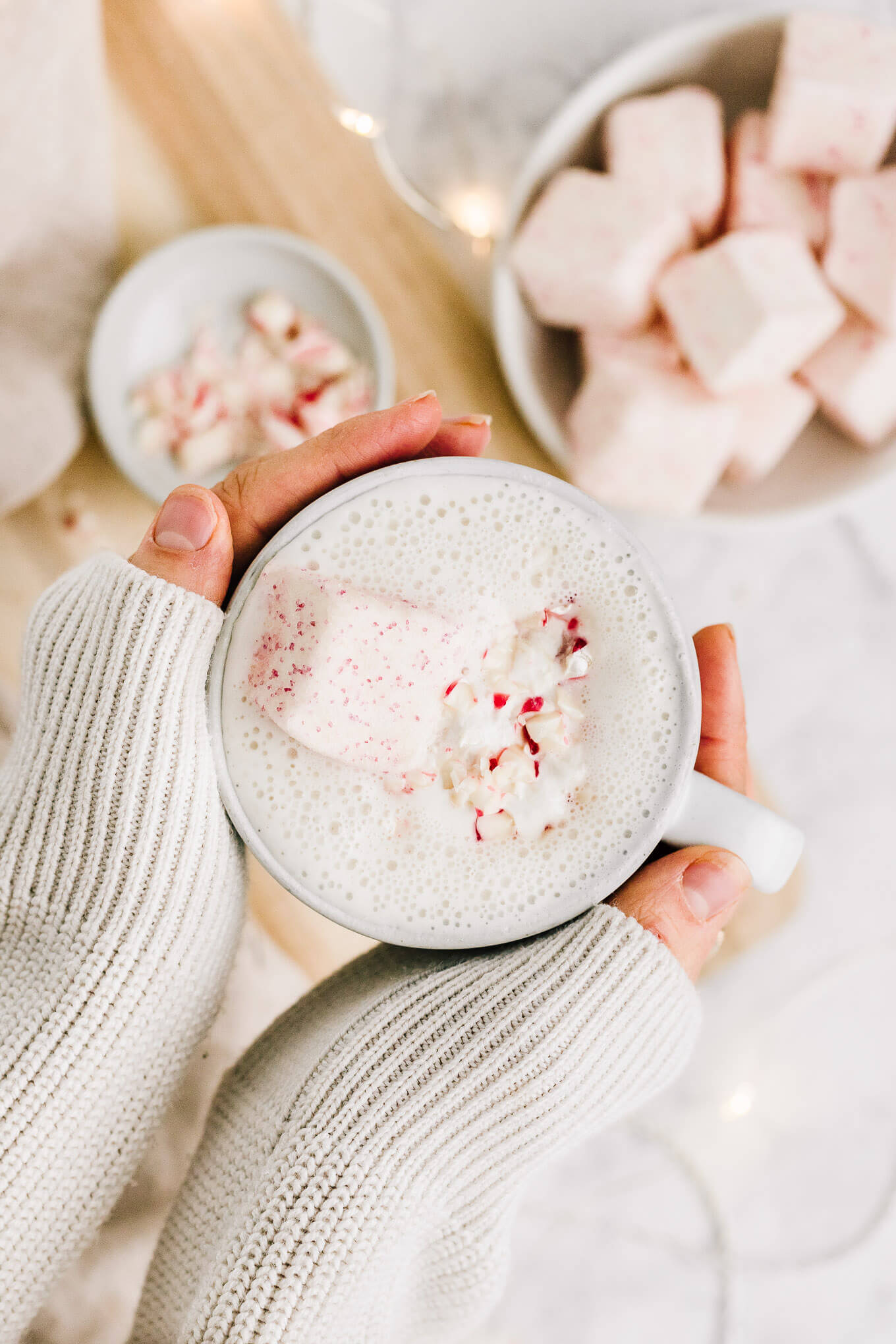 Hands holding vegan peppermint white hot chocolate